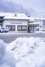 Tourist information centre with cars in the snow, situated under snow-covered roofs, Enzklösterle,