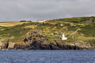 Tater-du lighthouse on rocky coast, Penzance, Cornwall, England, United Kingdom