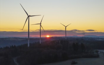 Wind turbines at sunrise with a road in the foreground, Rems Valley, Baden-Württemberg, Germany