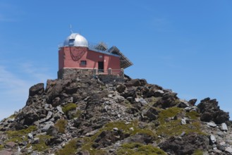 Close-up of a red observatory on a rocky hill under a blue sky, Obversatorium, Mohon del Trigo