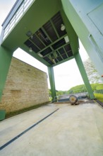 Industrial structure with green construction and machinery on an outdoor concrete floor, Glems