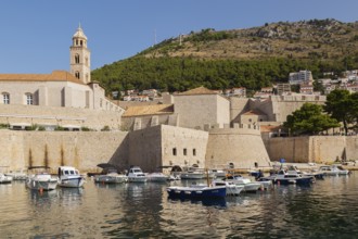 Old walled city of Dubrovnik with Dominican Monastery bell tower and Zrinski sightseeing tour boat
