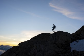 Silhouette of a photographer in front of a blue sky, mountain landscape at sunset, Chamonix,