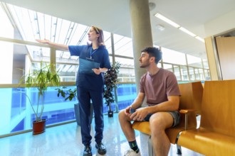 Female nurse holding a clipboard, providing instructions to a male patient seated in a bright,