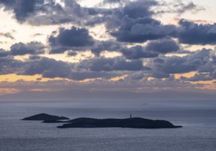 Nisos Gaidaros island with lighthouse in the sea at sunrise with dramatic clouds, Ermoupoli, Syros,