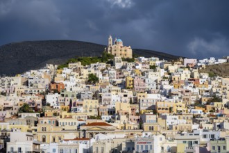 View of the town of Ermoupoli with pastel-coloured houses, on the hill Anastasi Church or Church of