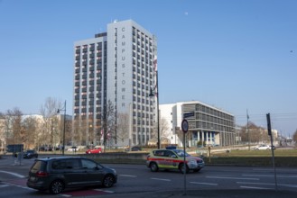 Modern high-rise building in the sunshine with passing cars, Campus Tower of the Otto-von-Guericke