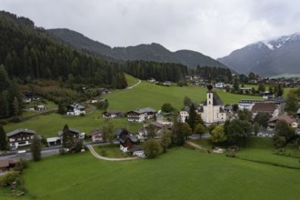 Drone shot, view of village with parish church, Waidring, Pillerseetal, Tyrol, Austria