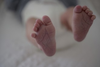 Close-up of baby's feet on a soft surface, blurred background