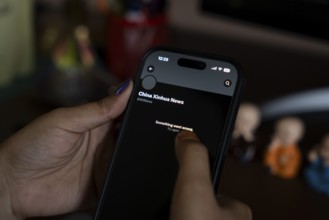 In this photo illustration, a person browsing Xinhua News Agency X account as India bans Chinese