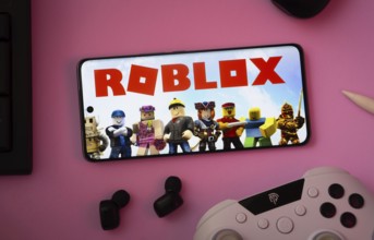 Dhaka, Bangladesh- 26 July 2025: A close-up of a gamepad with the Roblox seen on smartphone