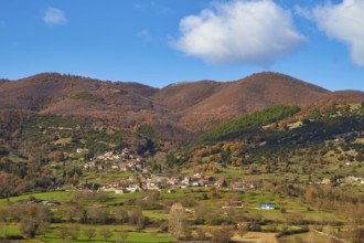 View of a village surrounded by autumnal hills and meadows, Erymanthos Mountains, northwest of the