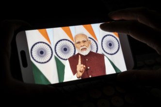 A person watches PM Narendra Modi's address to the nation after Operation Sindoor, on a mobile