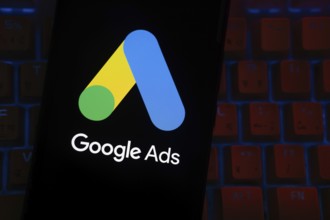 The logo of the Google Ads is displayed on a smartphone screen