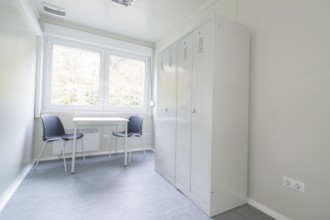 Simple office with desk, two chairs, a cupboard and large window, refugee accommodation Beermiß,