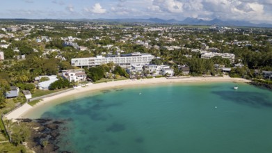 Bird's eye view of aerial view of lagoon and public sandy beach, with the village of Péreybère,