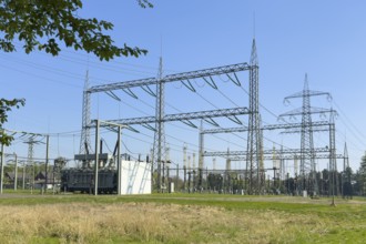 Substation with open-air switchgear for power distribution, in the background high electricity