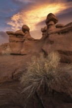 Stunning sandstone formations at Goblin Valley State Park, Utah, bask under a dramatic sunset. The