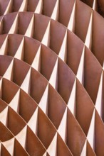 Close-up of an abstract, rhythmic arrangement of alternating rusty and white metal fins forming a