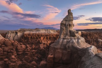 Majestic sandstone formations in Goblin Valley State Park, Utah, glow under a vibrant sunset sky,