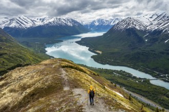 Climbers on a hiking trail on Slaughter Ridge, views of snowy mountains in spring and turquoise