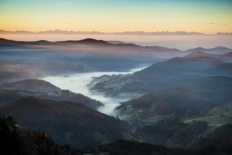 View from Belchen heading south of Wiesental and the Swiss Alps, morning atmosphere with fog in