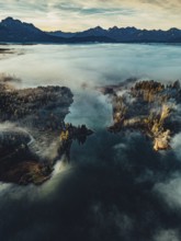 Autumn sunrise in the foothills of the Alps with fog at Illasbergsee and Forggensee near Halblech