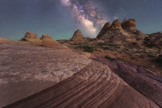Stunning view of the Milky Way illuminating a rocky desert with unique formations, capturing the