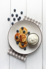 Cottage cheese pancakes, with blueberries, breakfast, on a white wooden table, no people, top view
