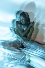 A futuristic depiction of a young African woman immersed in the metaverse, enveloped in blue hues