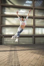 A joyful dancer in a colorful cropped top and jeans leaps gracefully, wearing headphones and
