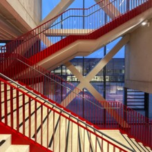 Staircase with signal red color scheme in seminar building H of Bochum University in the evening