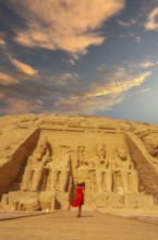 A European tourist in red dress walking towards the Abu Simbel Temple in southern Egypt in Nubia