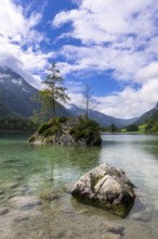 Hintersee near Ramsau with clear green water, surrounded by forests and mountains under a cloudy