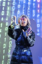 An elderly Asian woman with virtual reality glasses interacts in a digital metaverse environment.