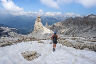 Female hiker on hiking trail 305 crossing a snowfield, Brenta Mountains, Parco Naturale