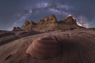 An awe inspiring view of the Milky Way galaxy illuminating the night sky above a rugged desert