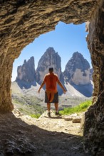 Tourist enjoying the breathtaking view of the tre cime di lavaredo, framed by a natural Tre Cime