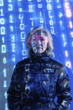 An elderly Asian woman wearing futuristic eyewear is immersed in the metaverse. Blue digital code
