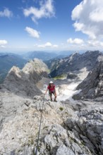 Mountaineer with helmet in a secured via ferrata, Zugspitze via ferrata, ascent to the Zugspitze,