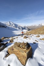 Mountaineer on a hiking trail with snow, descent from Ramoljoch at Spiegelferner, autumnal mountain