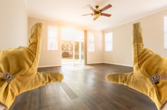 Contractor Hands In Leather Gloves Framing Empty Room of House