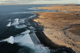 High-angle shot capturing the unique wave patterns and the sandy shore of Popcorn Beach in