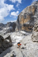 Climbers on the Via Ferrata Brentari via ferrata, spectacular mountain landscape with steep cliffs,