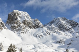A breathtaking view of snow-laden mountains under a clear blue sky, perfect for adventurous winter