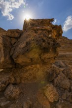The morning sun shines over a reddened rock, Huqf stone desert, Arabian Peninsula, Sultanate of