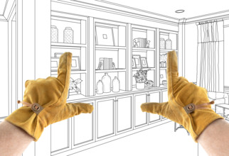 Male Contractor Hands Framing Over Built In Design Drawing