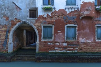 Old house with gate entrance to the canal, Venice, Veneto, Italy