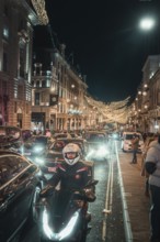 Nocturnal street scene with traffic, motorbikes and bright lighting, New Year's Eve London, Great