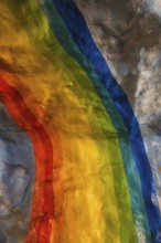 A colorful rainbow mural painted on a textured wall in Stockholm. The vivid hues contrast with the